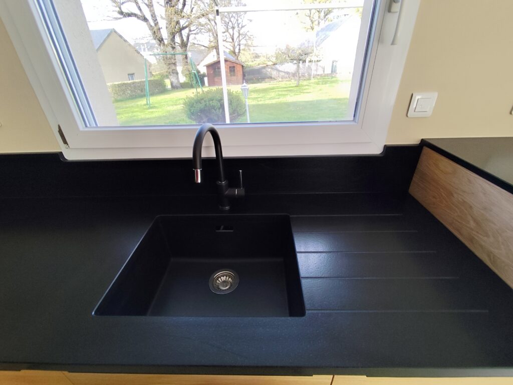 cuisine sur mesure complète en granit Noir Zimbabwe finition cuir, plaque de cuisson intégré, évier collé par dessous avec rainures, ensembles de plinthe et crédence. dessus de meule est table pour manger en granit également. Le tout passé avec un traitement hydrofuge pour garantir ça tenue dans le temps.