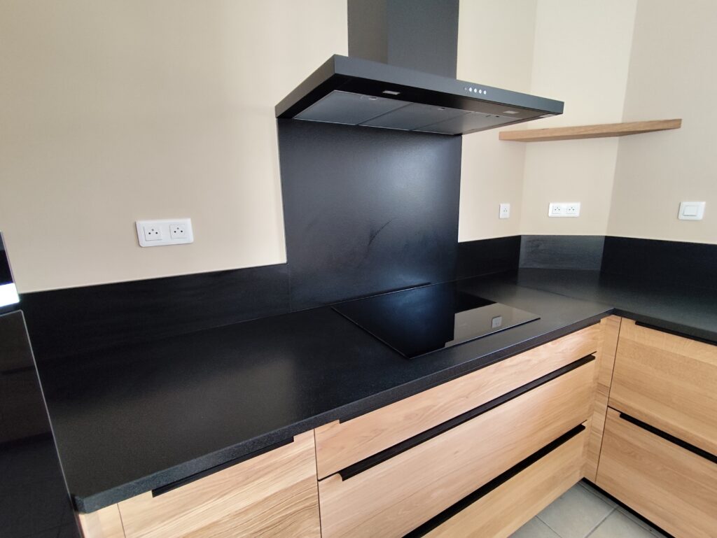 cuisine sur mesure complète en granit Noir Zimbabwe finition cuir, plaque de cuisson intégré, évier collé par dessous avec rainures, ensembles de plinthe et crédence. dessus de meule est table pour manger en granit également. Le tout passé avec un traitement hydrofuge pour garantir ça tenue dans le temps.