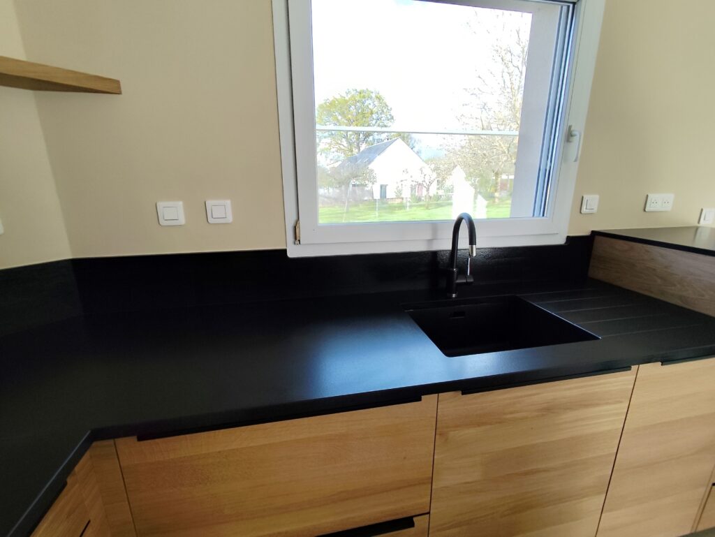 cuisine sur mesure complète en granit Noir Zimbabwe finition cuir, plaque de cuisson intégré, évier collé par dessous avec rainures, ensembles de plinthe et crédence. dessus de meule est table pour manger en granit également. Le tout passé avec un traitement hydrofuge pour garantir ça tenue dans le temps.
