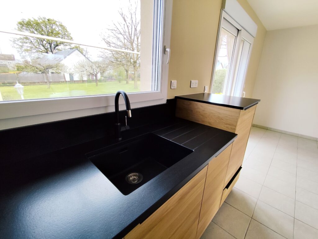 cuisine sur mesure complète en granit Noir Zimbabwe finition cuir, plaque de cuisson intégré, évier collé par dessous avec rainures, ensembles de plinthe et crédence. dessus de meule est table pour manger en granit également. Le tout passé avec un traitement hydrofuge pour garantir ça tenue dans le temps.